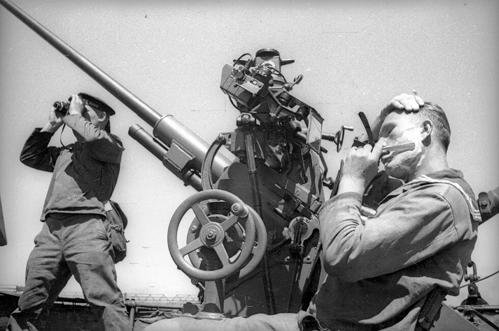Советский матрос бреется на палубе корабля рядом с 37-мм автоматическим зенитным орудием 70-К. Фото: Евгений Халдей/Общественное достояние